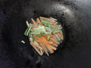 炒合菜,同时加入韭菜的根部，先行炒至