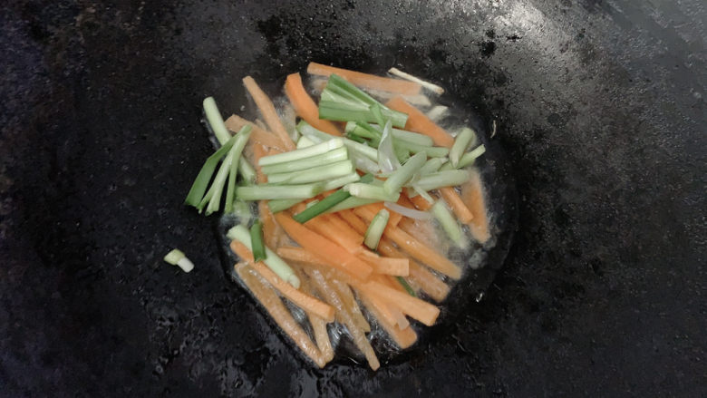 炒合菜,同时加入韭菜的根部，先行炒至