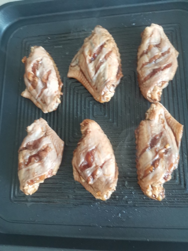 电饼铛蒜香烤翅,放入腌好的鸡翅，盖上盖子上下火180度烤3分钟