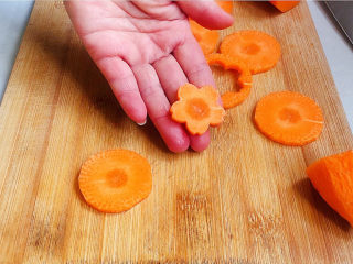 香辣鱿鱼圈,胡萝卜洗净，去皮，切二毫米厚片，再用梅花刀切成梅花型片