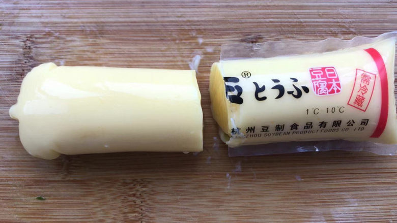 金针菇日本豆腐,豆腐一切为二，轻轻从包装里挤出豆腐。