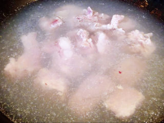 鹌鹑蛋烧排骨,锅中烧开水放入排骨，同时倒入料酒，焯水断生，去除多余的油脂和杂质。
