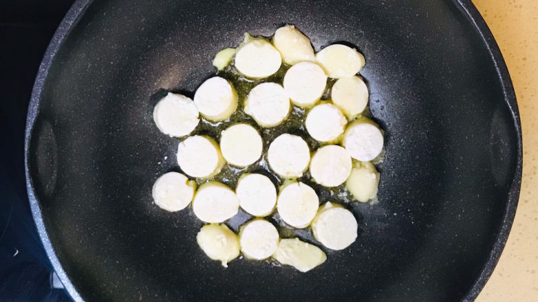 金针菇日本豆腐,将滚满淀粉的日本豆腐整齐地码放进油锅里