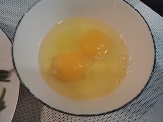 炒合菜,碗中打入两个鸡蛋。