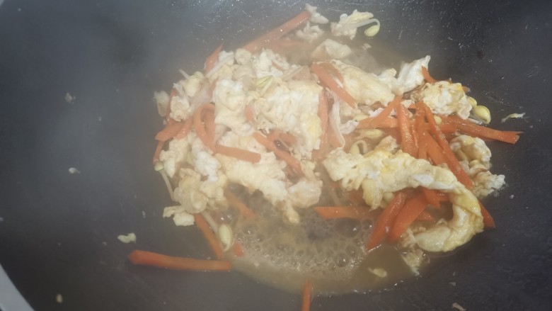 炒合菜,加入少量的清水，至胡萝卜和黄豆芽炒烂，加入鸡蛋。