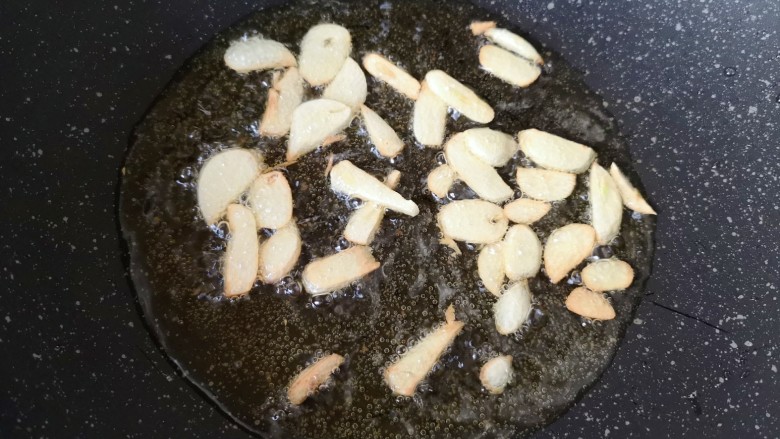 雪菜炒肉丝,炒锅内继续倒油烧热，下入蒜片炸至金黄色。