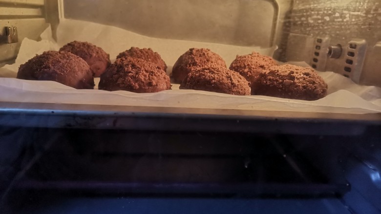 巧克力爆浆面包脏脏泥巴球,发酵好取出来，调整温度180度，预热10分钟，预热好后再送入烤箱烤20分钟
