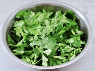 粉蒸芹菜叶,沥干水分的芹菜叶放入盆中，先加入食用油和盐翻拌均匀。