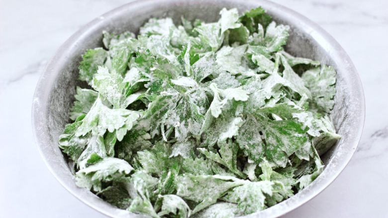 粉蒸芹菜叶,把芹菜叶和面粉搅拌均匀，芹菜叶片片都沾满面粉就可以了。
