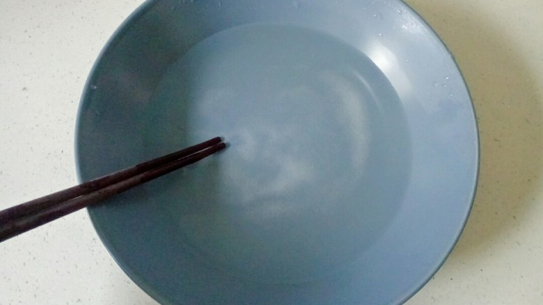 盐焗花生米,用筷子搅拌至盐化开