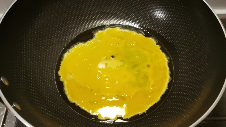 鸡蛋炒年糕,起油锅放入食用油，油热后放入鸡蛋。