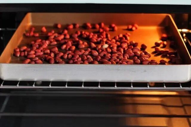 芝麻花生糖,烤箱提前上下火170度预热，将花生放入烤箱上层烤8-10分钟，注意别烤糊了。烤好后取出晾凉，搓掉外皮擀压成花生碎，如果花生颗粒较小就用整颗的。
