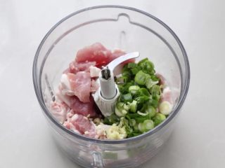 萝卜丝汤,将猪肉切成小块，同切碎的葱花和蒜末一起放进料理机中。