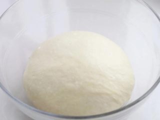 紫米面包,将面团整理好放进容器中，表面覆盖保鲜膜放到温暖处进行基础发酵。