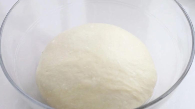 紫米面包,将面团整理好放进容器中，表面覆盖保鲜膜放到温暖处进行基础发酵。