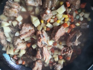 排骨糯米饭,开盖放入土豆和杂蔬翻炒均匀