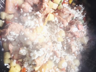 排骨糯米饭,把炒好的排骨杂蔬一起倒入电饭锅里，搅拌均匀