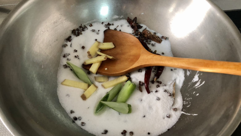盐焗花生米,放入葱段姜片，继续小火翻炒，炒香