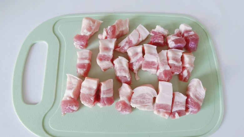 梅干菜烧肉,五花肉用温水洗一下，放在案板上切成小块。