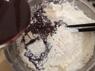 黑米馒头,把放温的黑米糊慢慢加入到面粉里，边加边搅拌