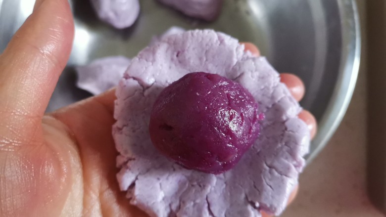 紫薯糯米糍,取一个糯米面团剂子按压成饼状，包入紫薯馅，像包汤圆一样，收口捏紧