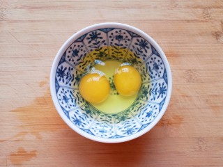 鸡蛋炒年糕,鸡蛋磕入碗里打散。