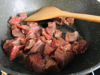 简单美味的杏鲍菇牛肉粒,锅里放油，下入牛肉粒划至变色。
