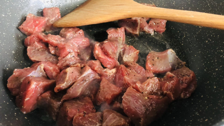 简单美味的杏鲍菇牛肉粒,锅里放油，下入牛肉粒划至变色。