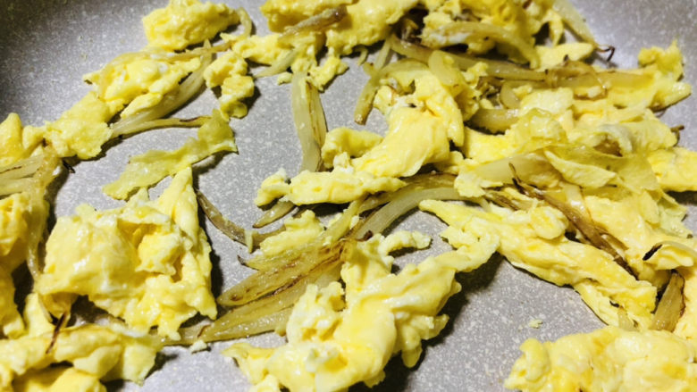 鸡蛋炒年糕,待洋葱炒香后，倒入打散的鸡蛋液炒成块状。