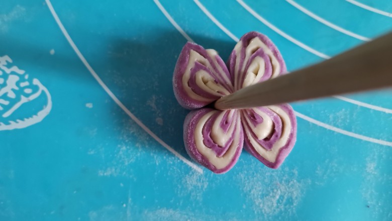 紫薯花朵馒头,把2个剂子为一组，放在一起，用筷子从中间夹一下