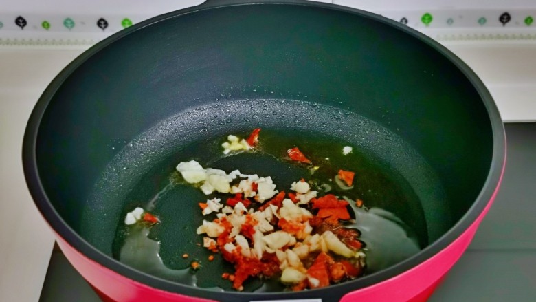 清炒四季豆,起油锅，加入蒜末与辣椒煸炒。