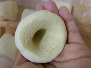 玉米面窝窝头,取一个面剂，拇指插入，其余四指包紧并旋转面剂。