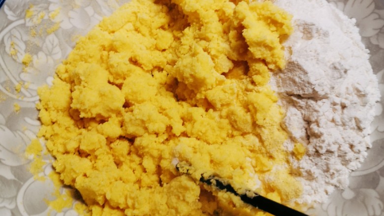 玉米面窝窝头,玉米面粉部分倒入适量开水，搅拌均匀。