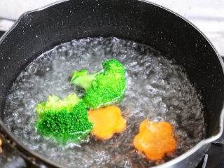 爆浆鸡排,锅中注入清水烧开，先加入1小勺盐和1勺食用油，再放入西兰花和胡萝卜，焯熟后捞出放入盘中备用