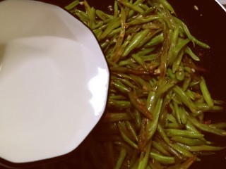 清炒四季豆,倒入一小碗清水。