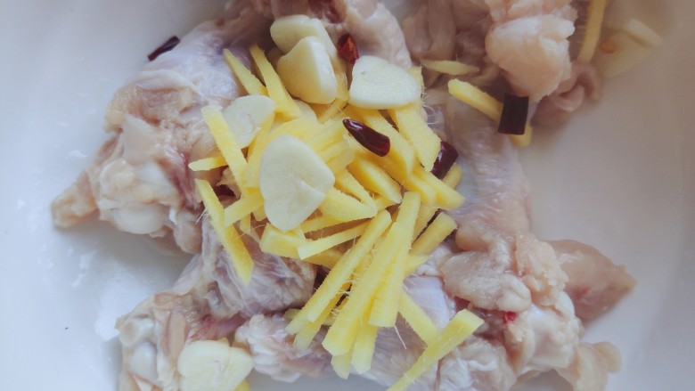 鸡肉炖土豆,将生姜丝，大蒜片，干红辣椒全部放入鸡翅根内