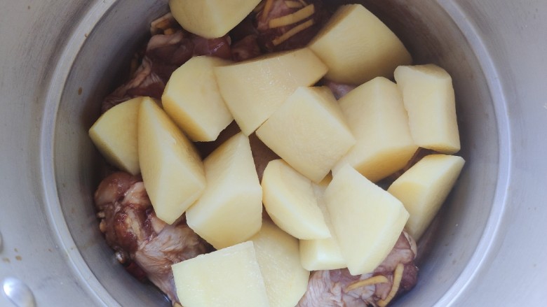 鸡肉炖土豆,将腌制好的鸡翅根连同酱汁一起倒入高压锅内，加入土豆块儿