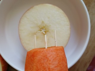水果圣诞树🎄,胡萝卜尾尾部和半个苹果用牙签链接，形成底座和树干。