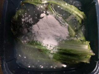 莴笋叶香米饭,水中放一勺盐和面粉搅拌均匀，把莴笋叶浸泡片刻。