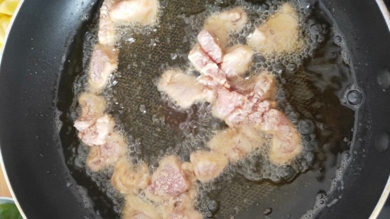 菠萝咕噜肉,油烧至9分熟，放入腌制好的里脊肉入锅炸