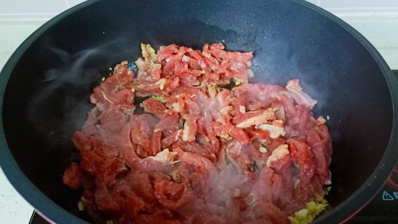 尖椒牛柳,锅里放适量的食用油，把蒜泥爆香，再下牛肉丝翻炒。
