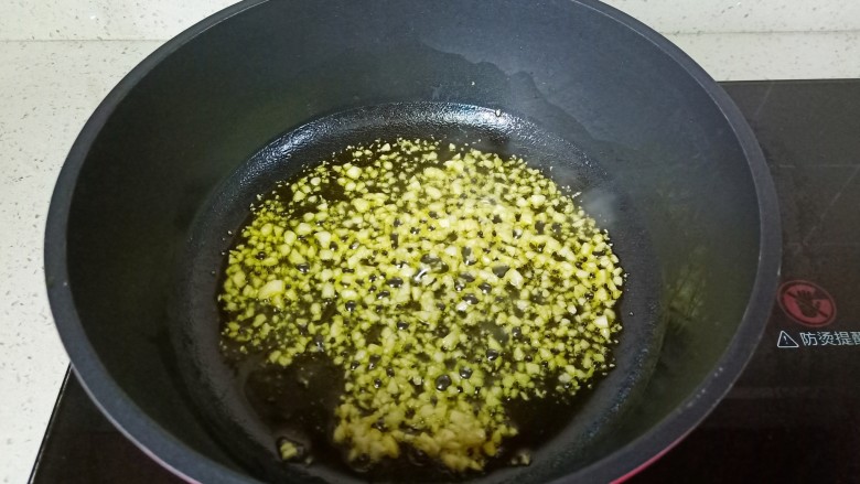 清炒四季豆,热锅凉油将蒜泥炒成金黄色。
