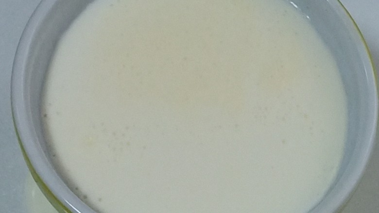 红豆双皮奶,过筛厚的牛奶再缓缓的沿着蒸器的边缘倒入。奶皮就会浮在上面了，如图。