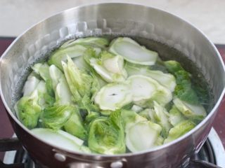 清炒儿菜,锅中烧开水，先下入儿菜的茎焯烫三十秒，再下入叶子烫三十秒，捞出过凉水沥干水分。
