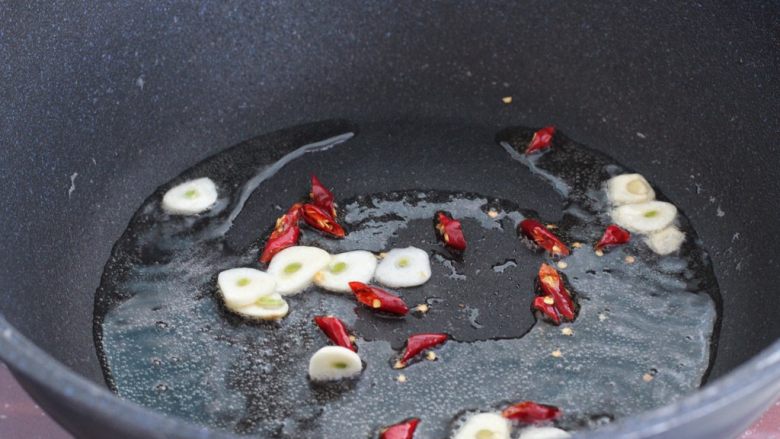 清炒儿菜,锅中倒适量食用油烧热，下入蒜片和红干椒小火炒出香味。