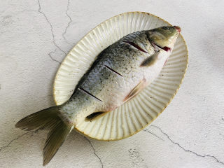 冬瓜鲫鱼汤,鲫鱼去鳞去内脏清洗干净，在鱼的两面划三刀。抹上少许盐腌制十分钟