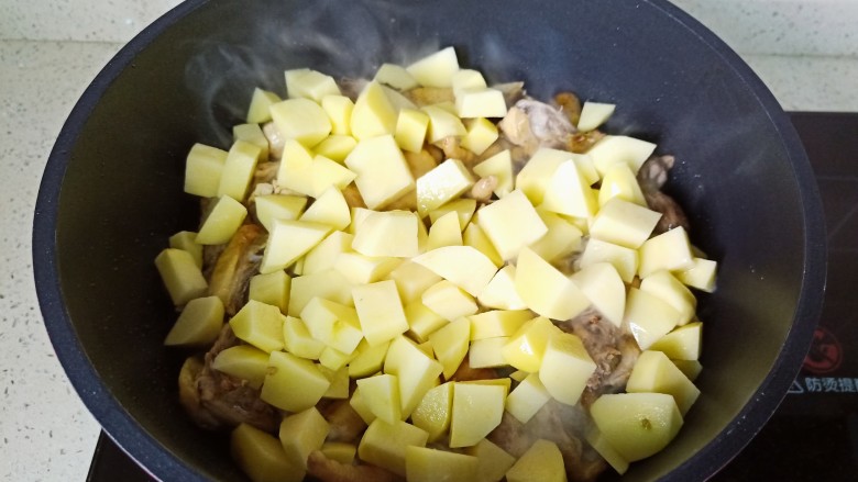 鸡肉炖土豆,加入切好的土豆块翻炒两分钟。

