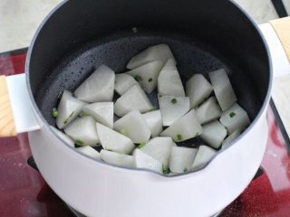 萝卜肉丸汤,汤锅中加入一勺食用油烧热，放入葱花小火炒出香味，再将萝卜块放进去翻炒均匀。