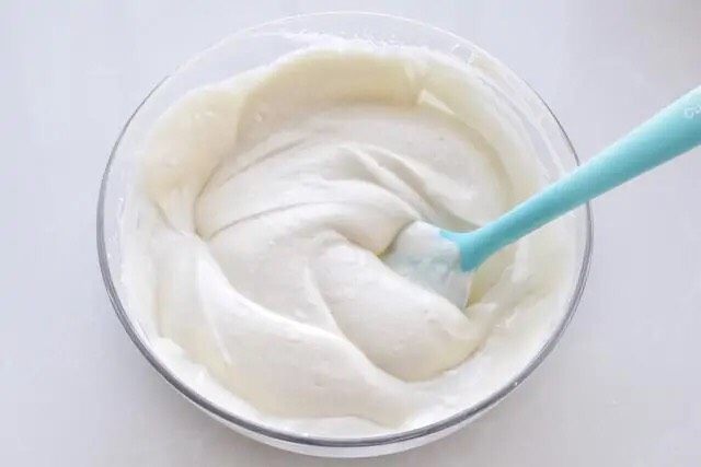 酸奶芝士蛋糕,再将拌好的面糊倒回剩下的蛋白霜中，用同样手法继续混合翻拌均匀，拌好的面糊应该是浓稠细腻的状态。