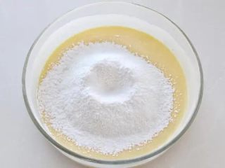 酸奶芝士蛋糕,将低筋面粉和玉米淀粉混合筛入蛋黄酸奶中，用打蛋器呈Z字形来回拌匀至顺滑状态。
